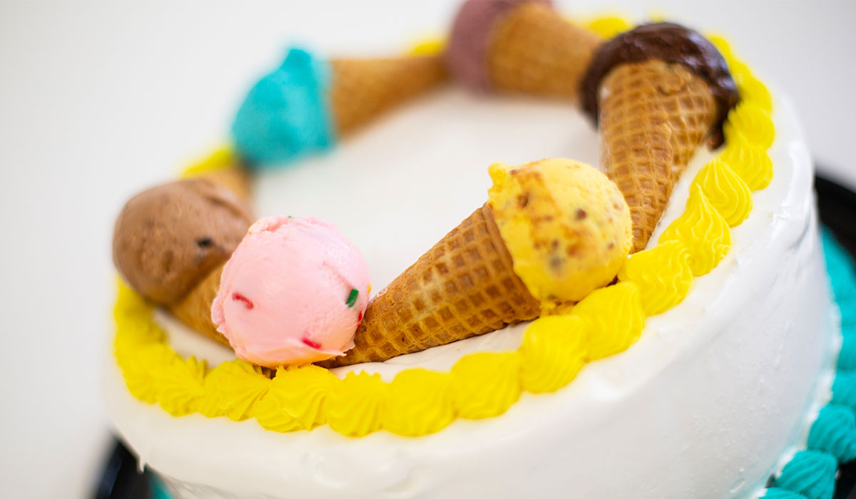 Close up of an 8" ice cream cake from Over The Top Ice Cream, featuring a ring of ice cream cones all filled with individual scoops of ice cream.
