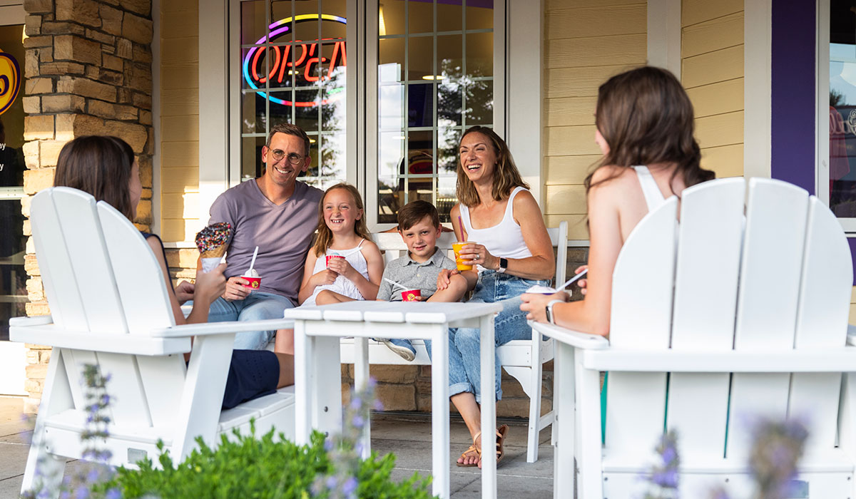 A family eating ice cream on the Over The Top Ice Cream patio.